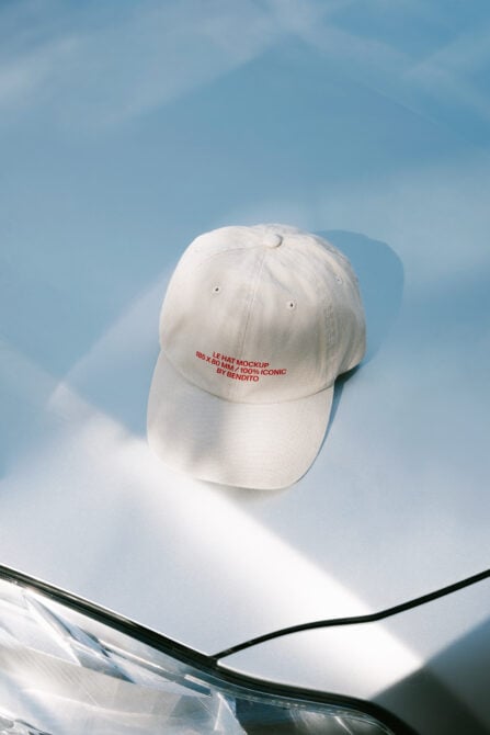 Cream colored dad hat on white surface against bright blue sky