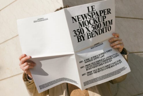 White newspaper mockup pages spread open, neutral tone with typography detail