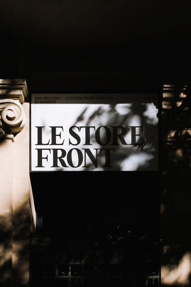 Storefront sign with serif typography on white background, architectural details visible