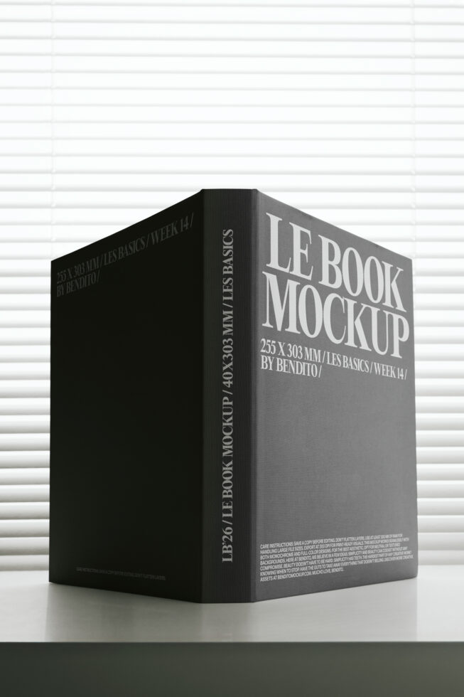 Black hardcover book mockup standing on white brick wall backdrop with serif typography
