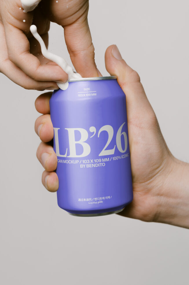 Beverage can mockup in purple with label text shown being held in hand