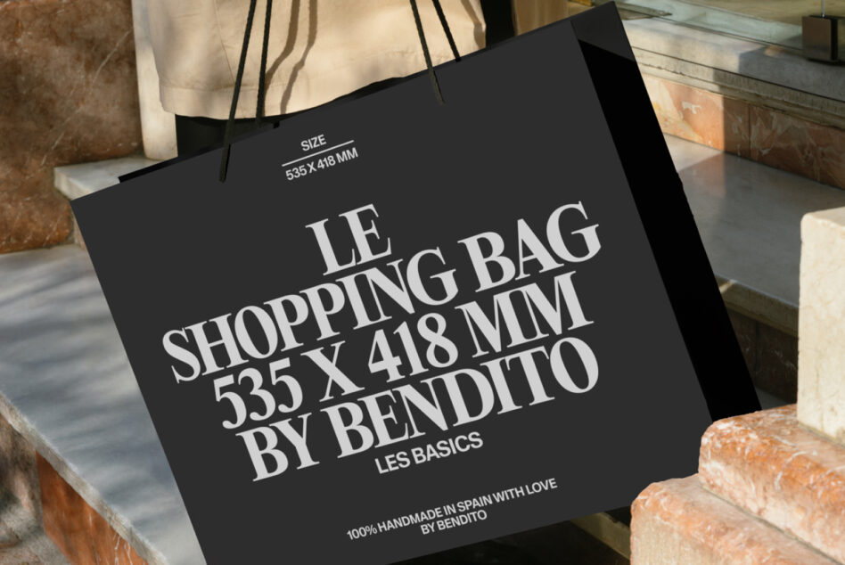 Black tote bag displaying serif text on stone steps, close-up detail shot
