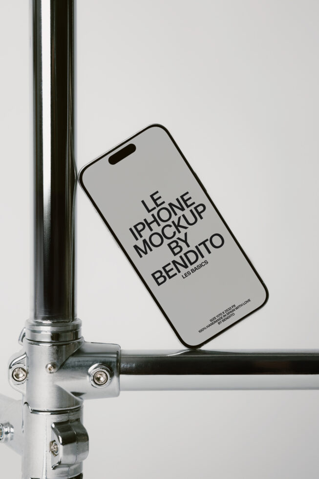 iPhone leaning against metal pole with light gray screen showing mockup text