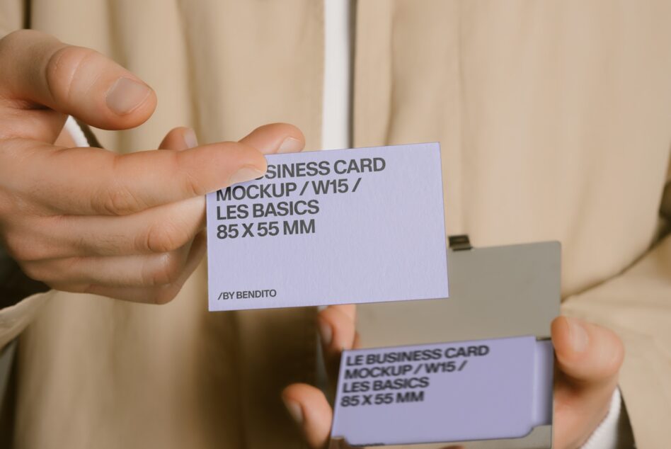 Pale purple business card held at angle with visible branding