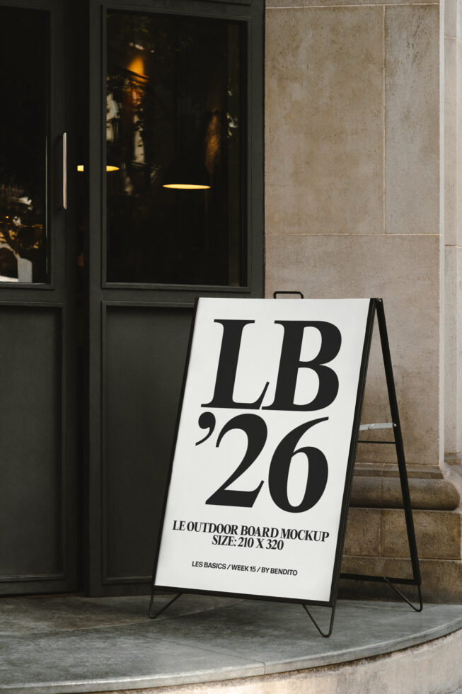 Off-white A-frame sidewalk sign with LB 26 on storefront street corner