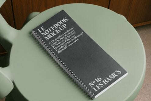 Dark cover notebook mockup flat lay on mint green round table with wood backdrop