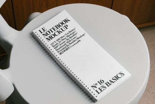 Light cover spiral notebook mockup centered on white round table interior scene