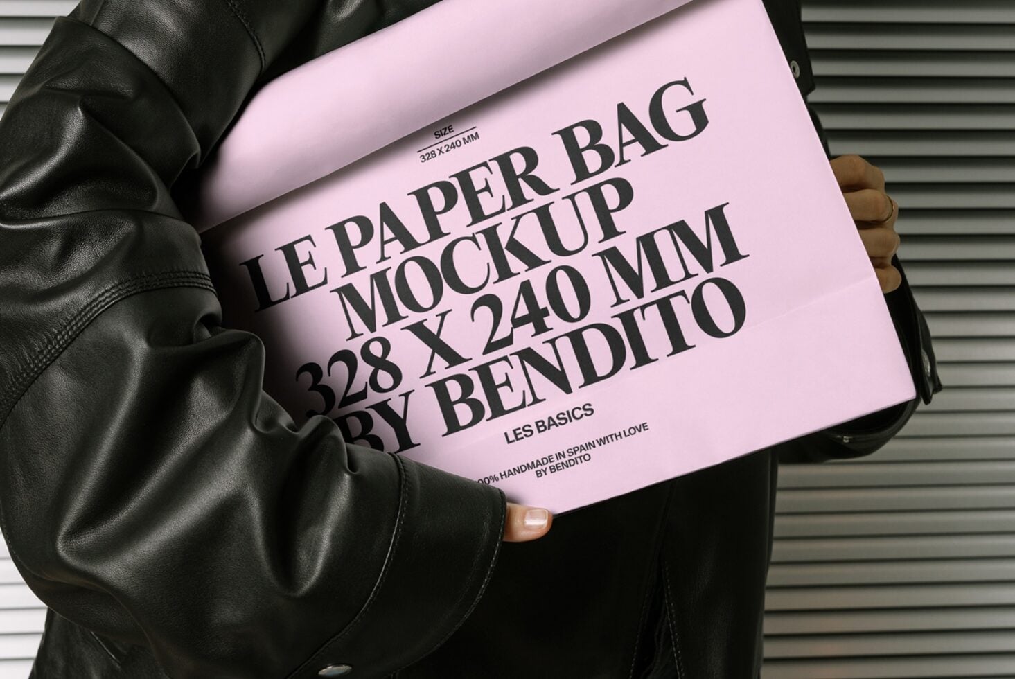 Pink paper bag mockup with black text layout on leather jacket background