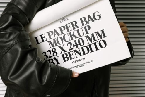 White paper bag mockup with black text on leather jacket against metal wall