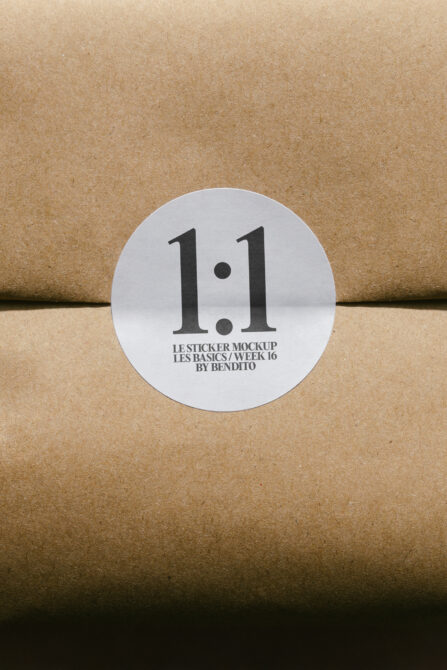 White circular sticker on kraft paper with bold typography display