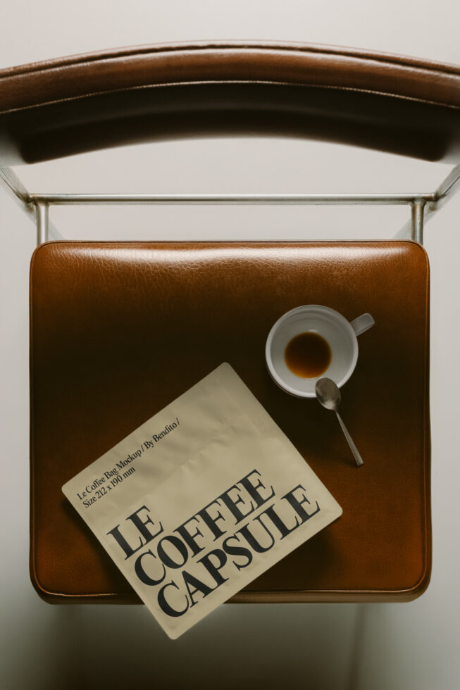Leather bag styled flat lay with coffee cup, spoon, plus Le Coffee Capsule product card