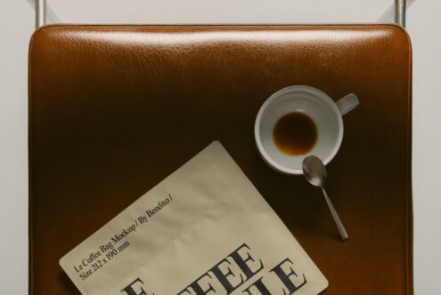 Top down view of tan leather bag holding espresso cup with saucer plus Le Coffee Bag card