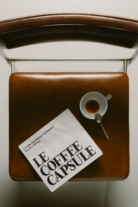 Leather bag styled flat lay with coffee cup, spoon, plus Le Coffee Capsule product card