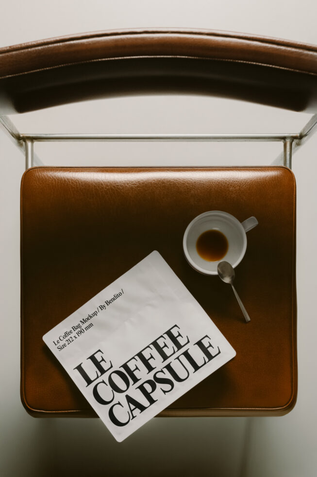 Leather bag styled flat lay with coffee cup, spoon, plus Le Coffee Capsule product card