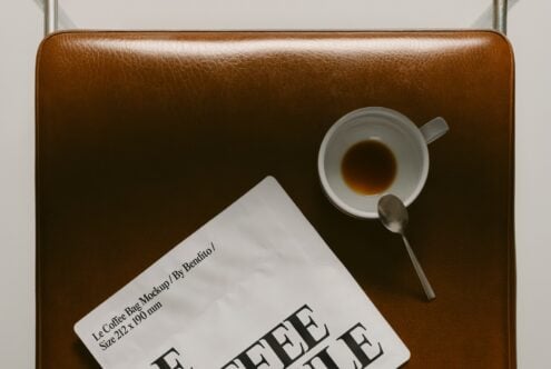 Top down view of tan leather bag holding espresso cup with saucer plus Le Coffee Bag card