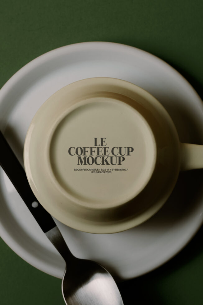 Top down view of cream cup in saucer on green background with spoon