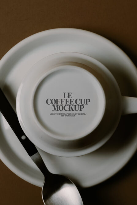 Overhead view of white cup in saucer on brown background with spoon