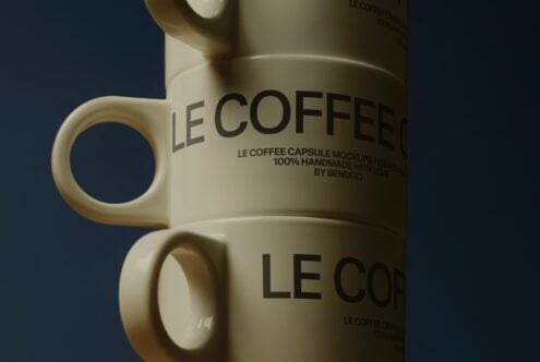 Close up of cream mug with Le Coffee Capsule Mockup text on dark blue