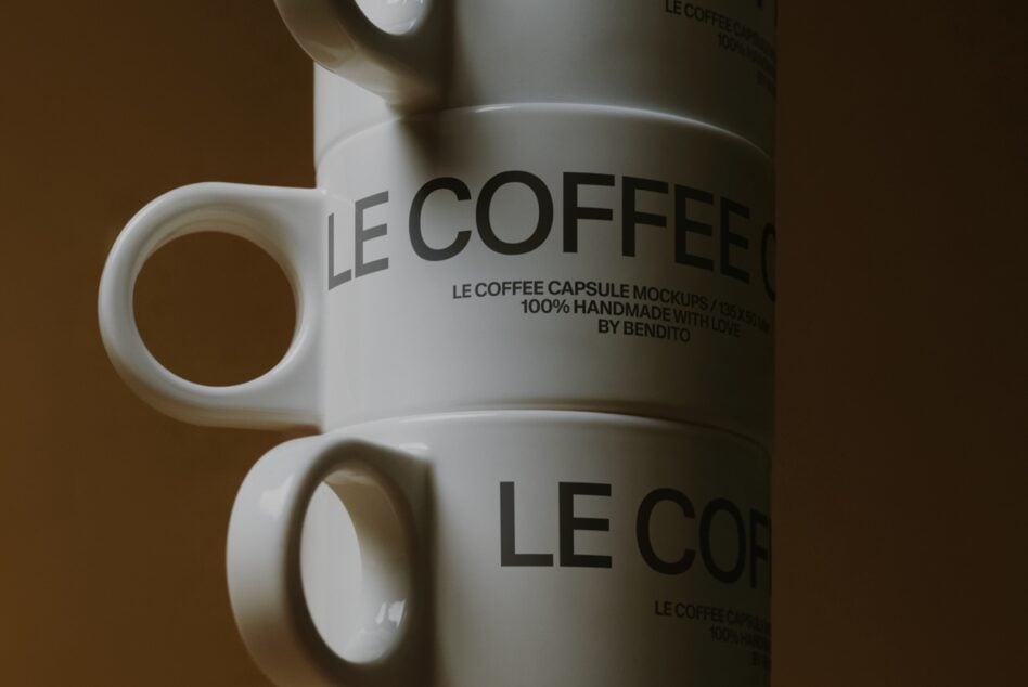 Close up of white mug with Le Coffee Capsule Mockup text on brown