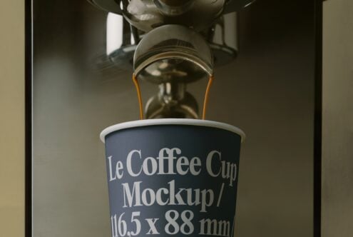 Overhead view of espresso extraction into navy cup with white sans-serif label