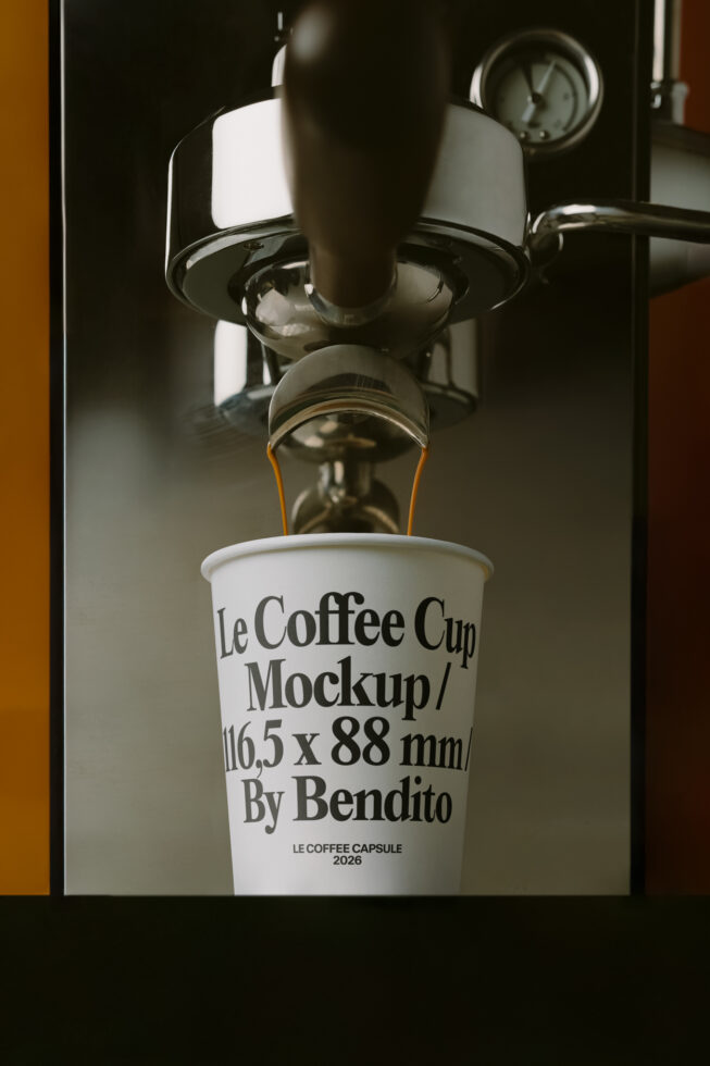 Coffee streaming from machine into white cup with serif typography on warm wall