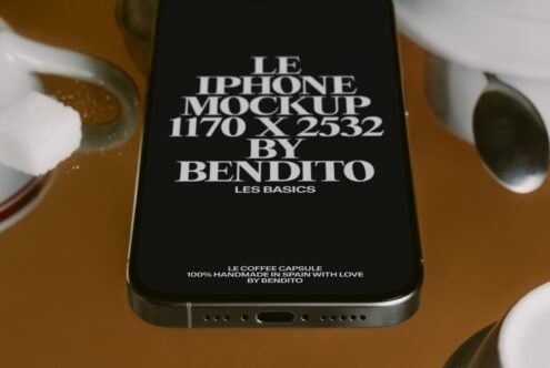 iPhone mockup on tan background with black screen, white ceramic cups, brass vessel