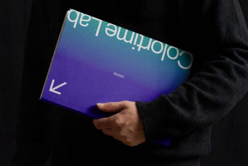 Hand holding gradient book cover shifting from purple to teal with text overlay