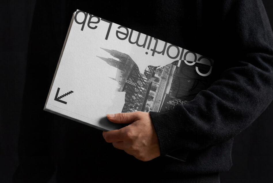 Black magazine held in hands with city architecture photo printed on cover