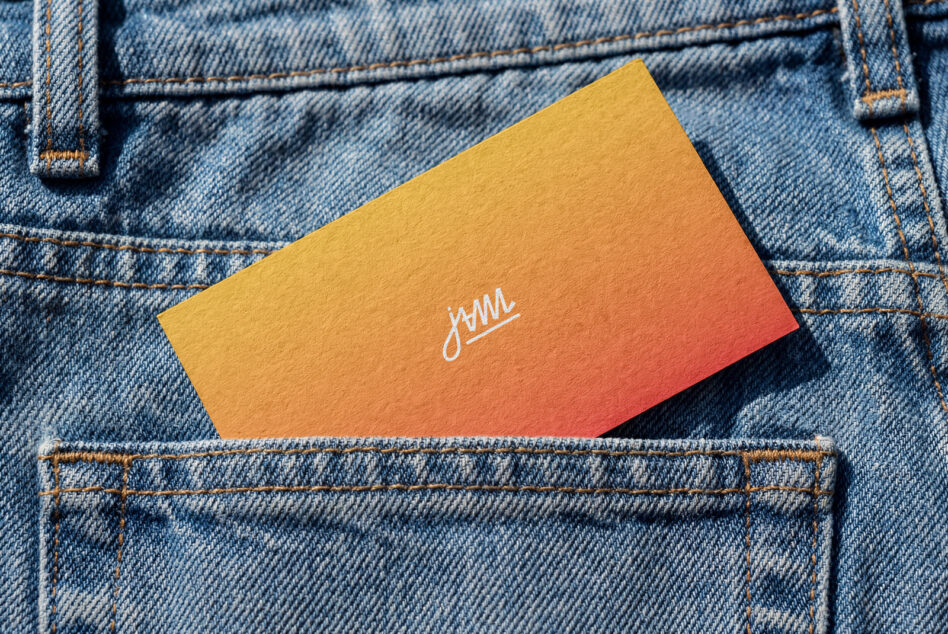 Gold to coral gradient business card with white script logo on denim texture