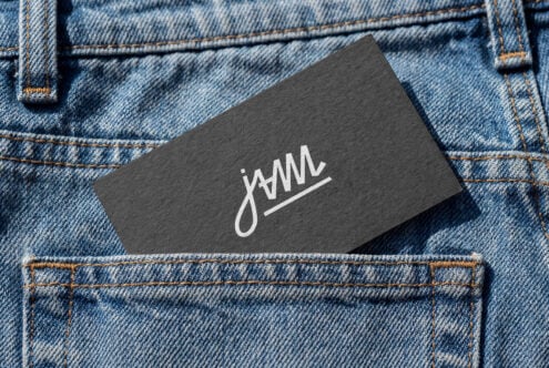 Dark business card with handwritten jWML logo in white on denim texture