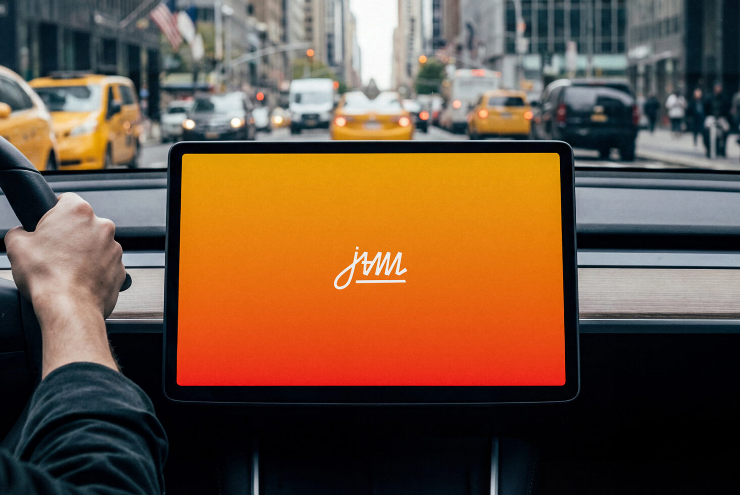 Tablet displaying cursive jam logo on orange to red gradient held in taxi