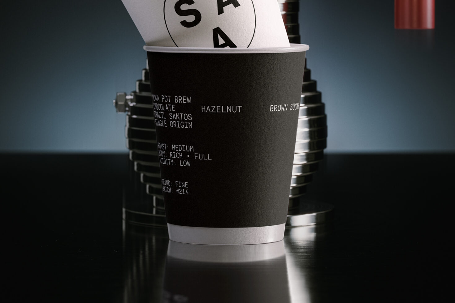 Black coffee cup with white lid showing roast details, hazelnut, brown sugar specs
