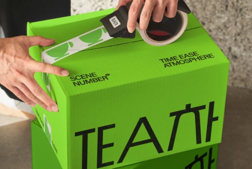 Hands opening bright green box with TEATT typography, tape dispenser visible