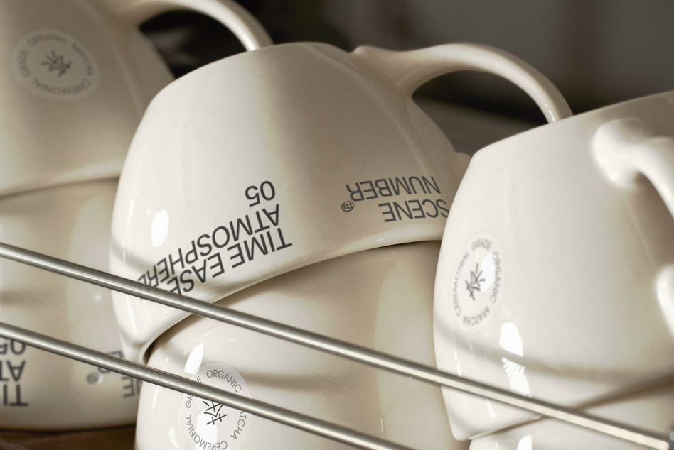 White ceramic mugs in close-up showing handle curves with logo placement