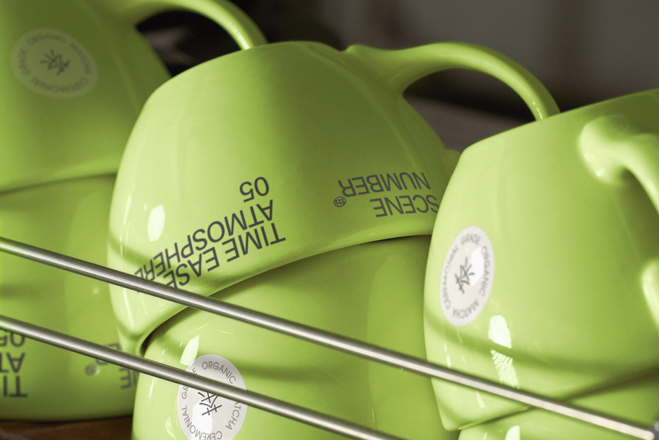 Lime green ceramic mugs arranged on shelf with curved handle detail visible