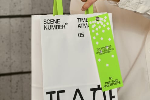 Hand holding white clapper board with lime green side panel mockup