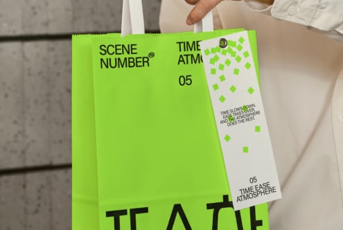 Person holding bright green clapper board with scene number 05 marker