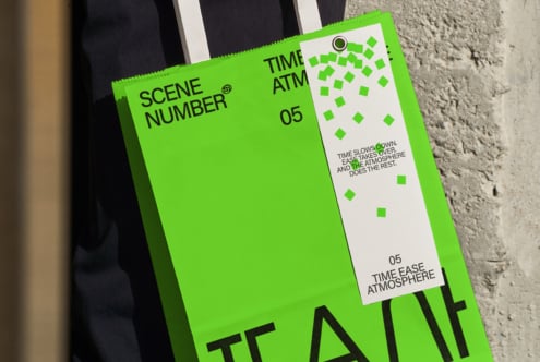 Neon green clapper board with white text labels, propped on concrete ground