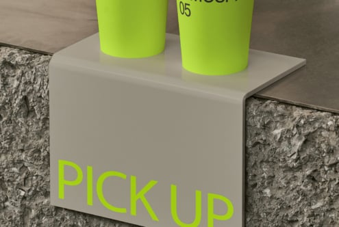 Overhead shot of two bright lime cups on white box on concrete surface