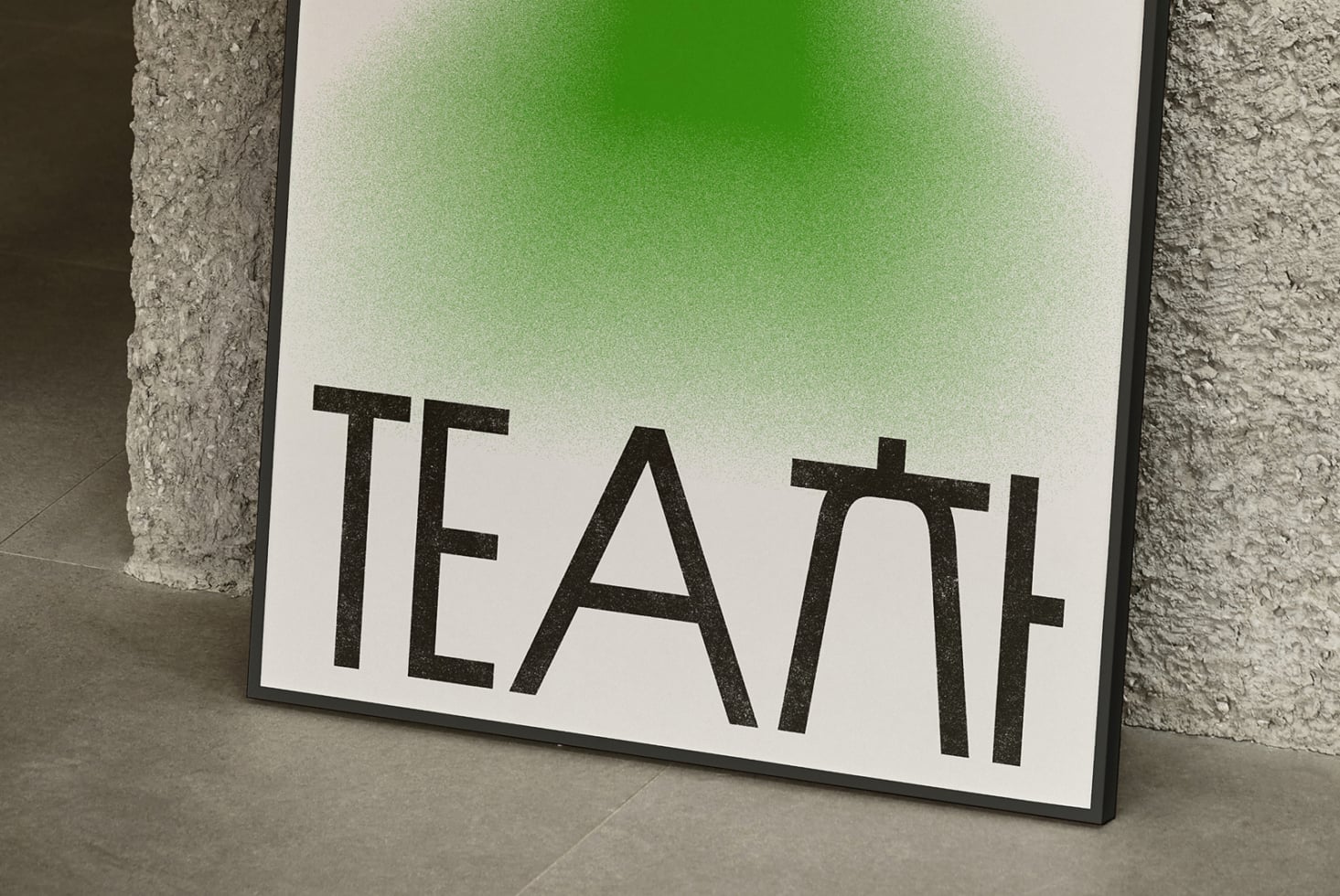 White poster with green gradient displaying TEAL text leaning against concrete wall