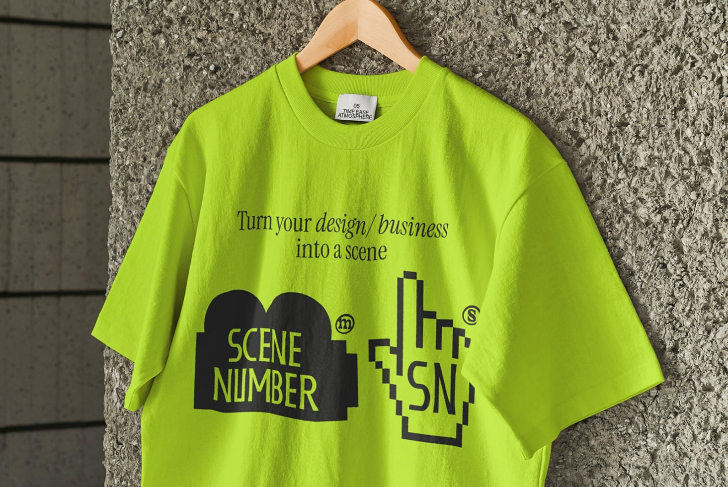 Bright lime tee with Scene Number branding displayed on wooden hanger