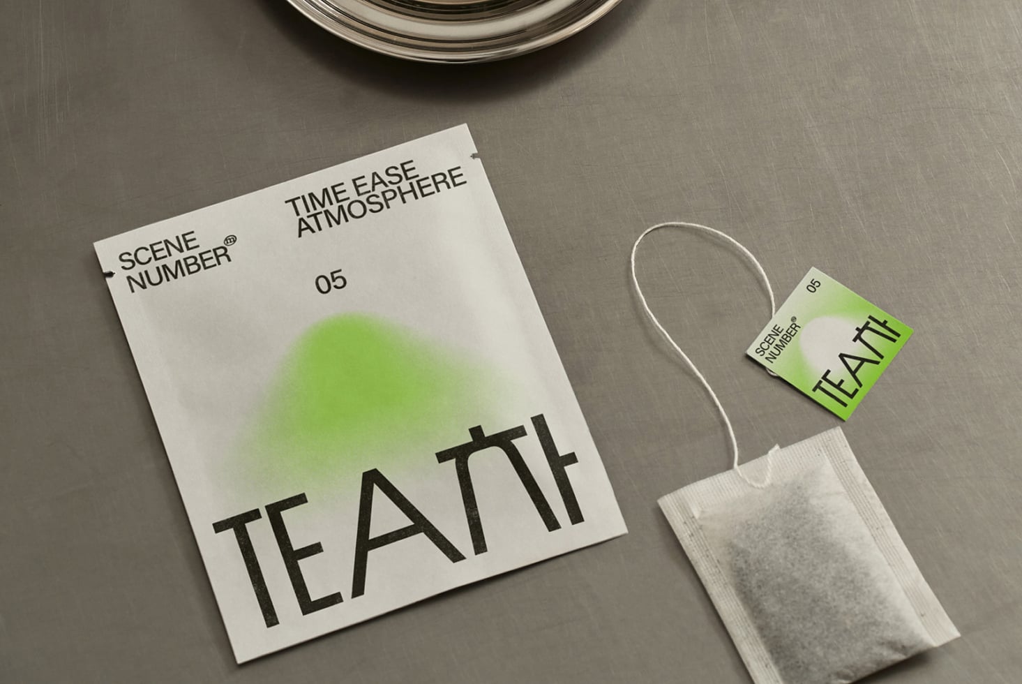 Overhead shot of tea packaging with tag attached, minimal styling on grey surface