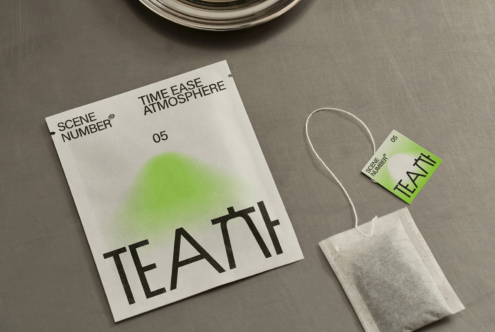 Overhead shot of tea packaging with tag attached, minimal styling on grey surface