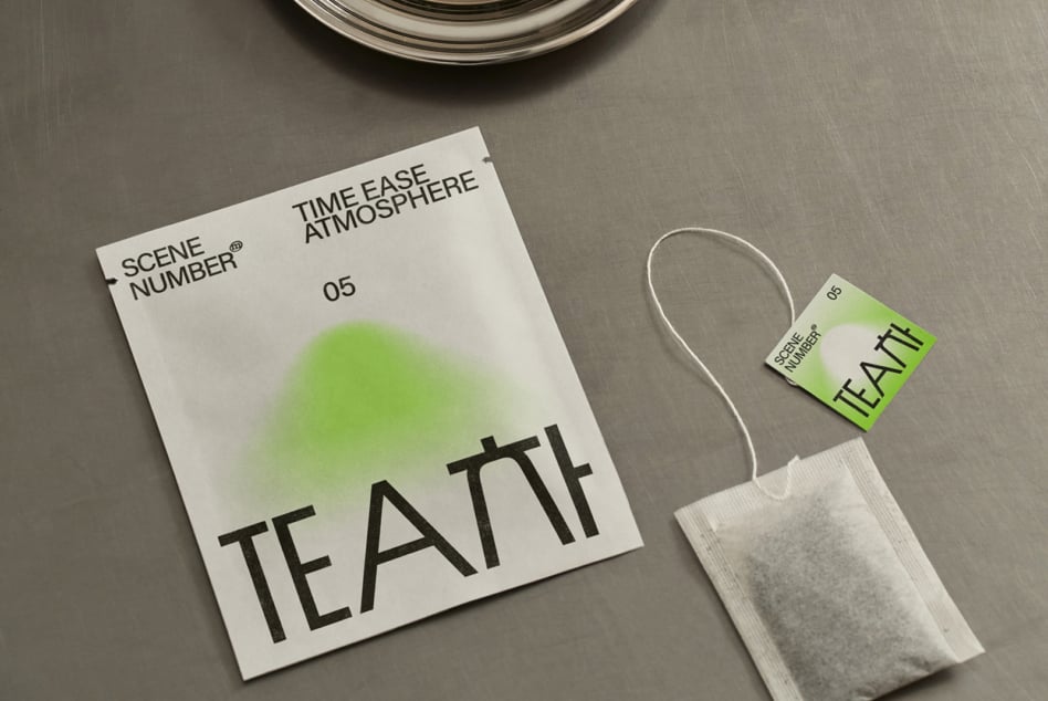 Overhead shot of tea packaging with tag attached, minimal styling on grey surface