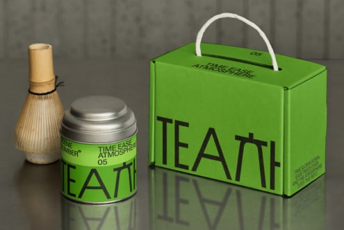 Bright green tea box with white handle next to metal canister mockup