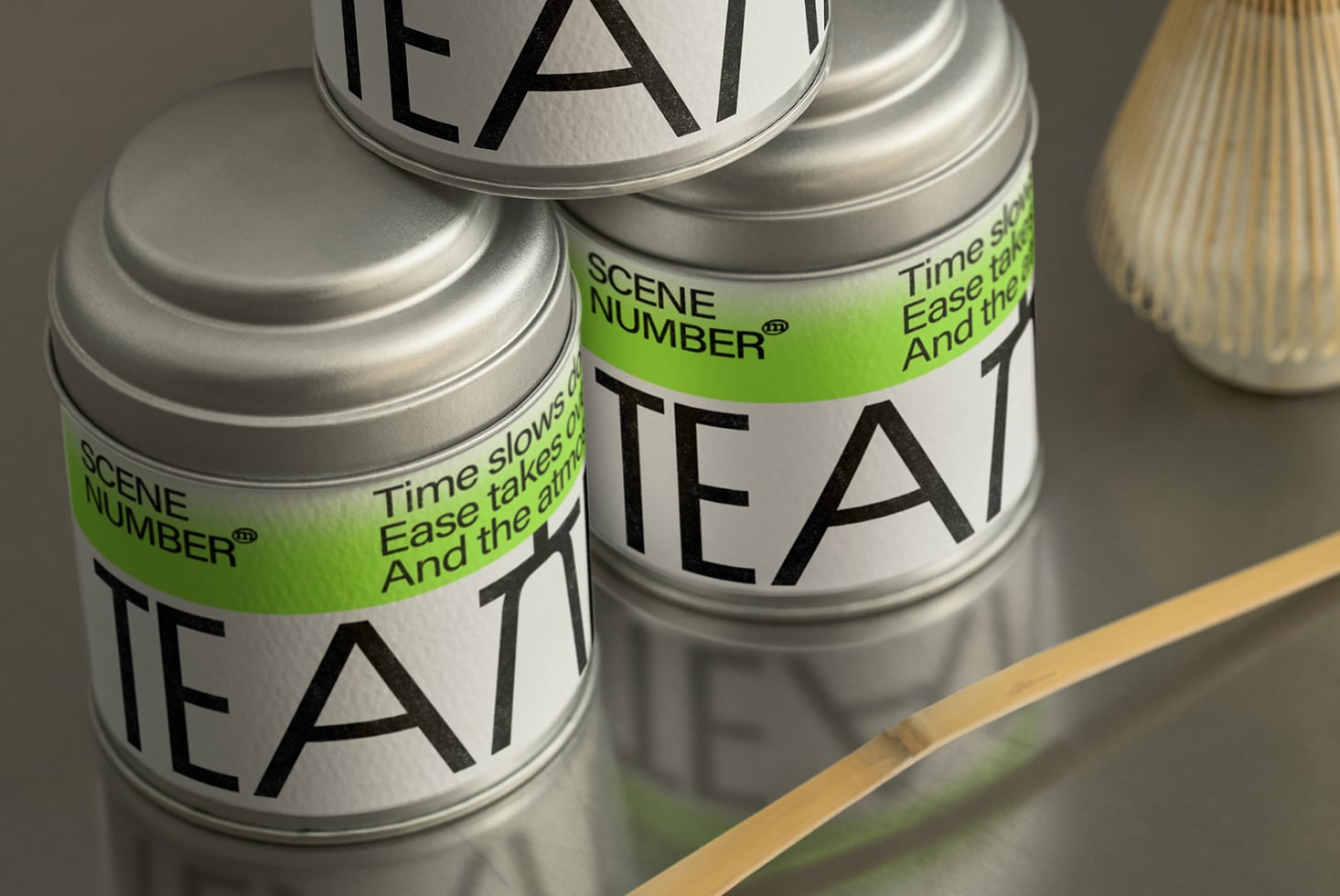 Silver tins with mixed green white labels lined up on wood surface