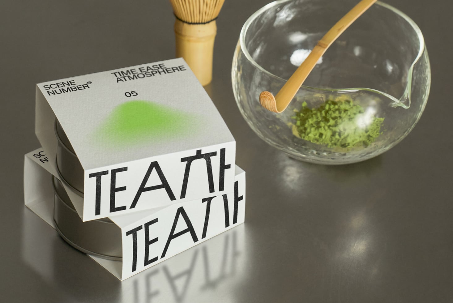 White packaging box with gradient green showing matcha preparation tools nearby