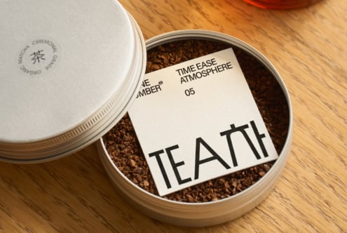 Open tea tin showing loose cocoa powder with product label inside