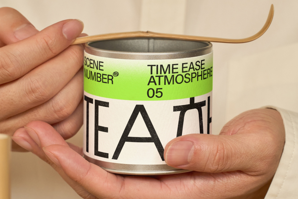 Hand holding open tin container showing interior label design for tea packaging