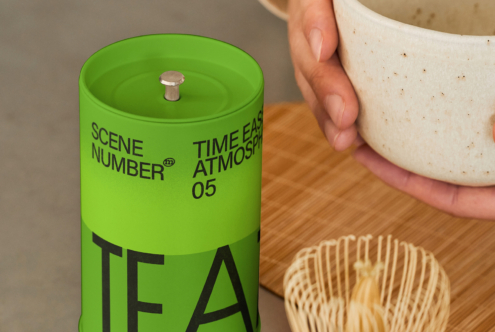 Green cylindrical tea canister with metal top on wooden table